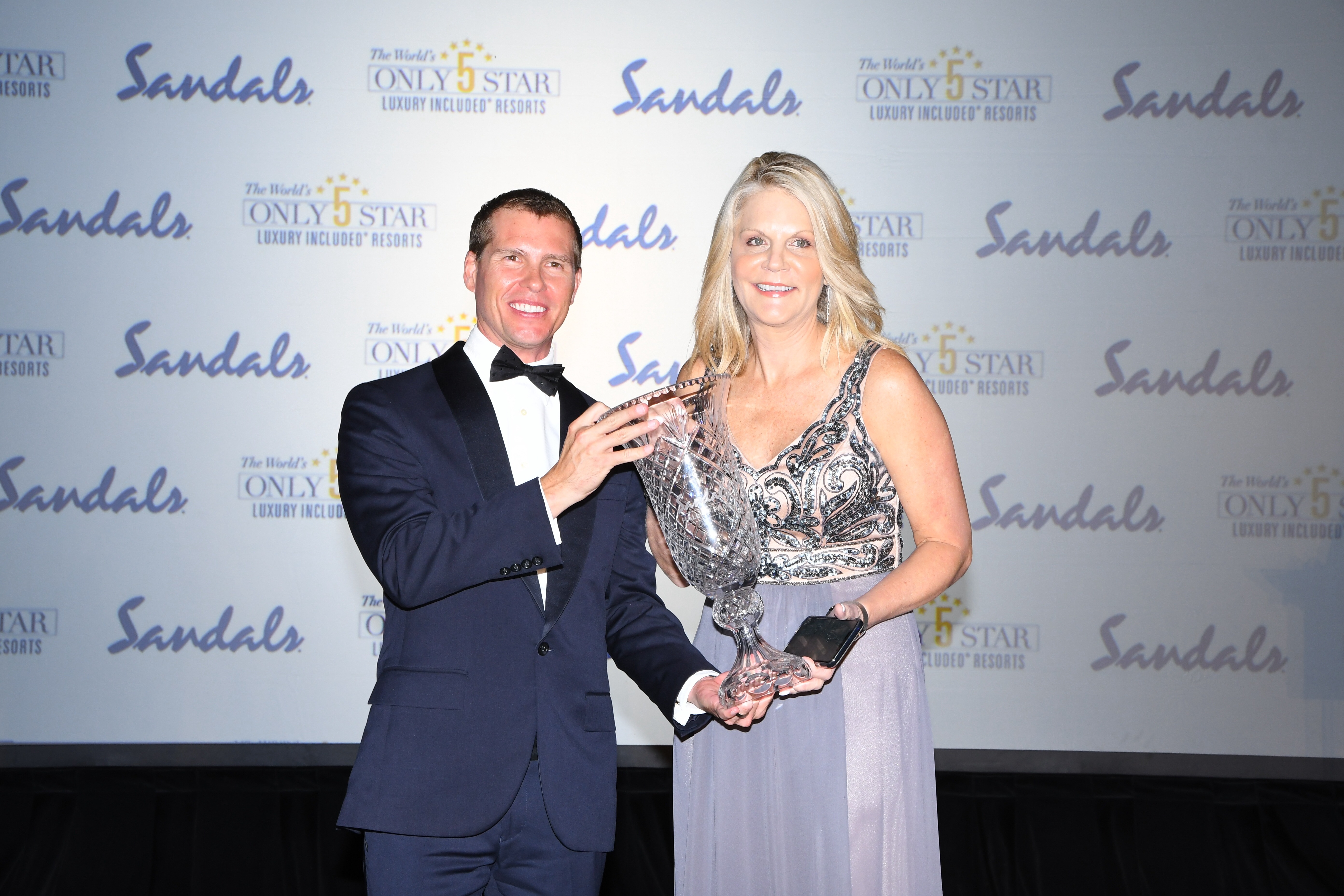 Michelle Fee, CEO of Cruise Planners, was inducted into Sandals Resort International’s Hall of Fame by Adam Stewart, Deputy Chairman of Sandals and Beaches Resorts in Turks & Caicos